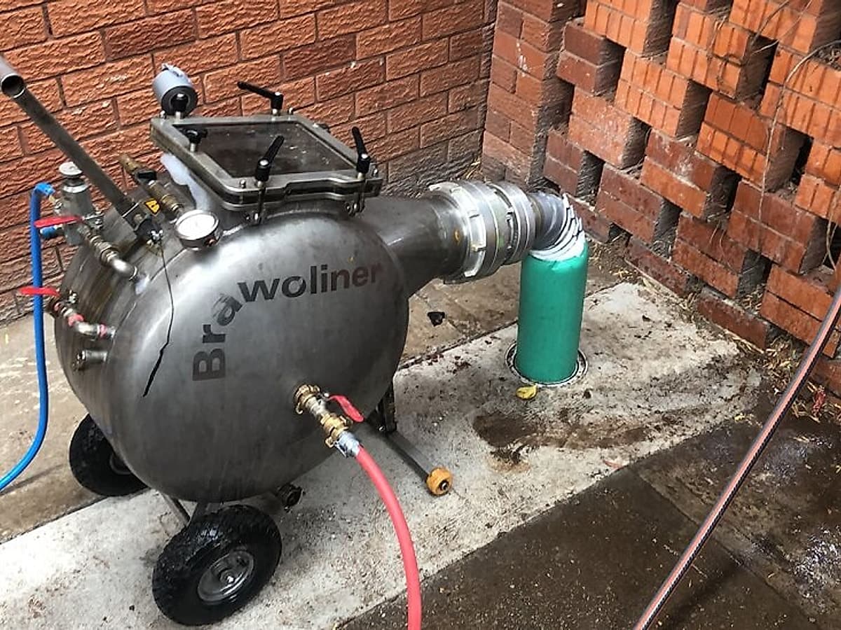 Sewer relining installation unit set up beside a property